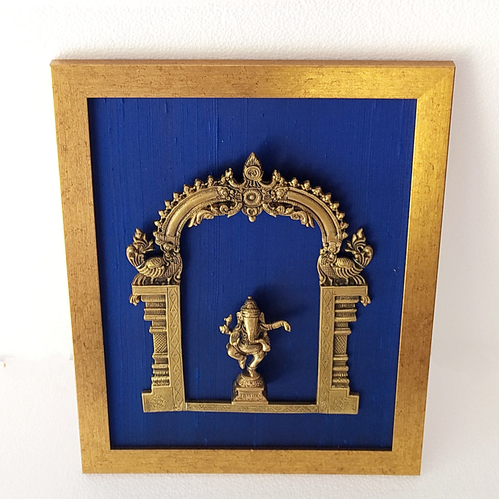 Divine Brass Prabhavali Framed On Deep Blue Raw Silk With Dancing Ganesha In Antique Gold Frame. Height 45 cm x Width 35 cm