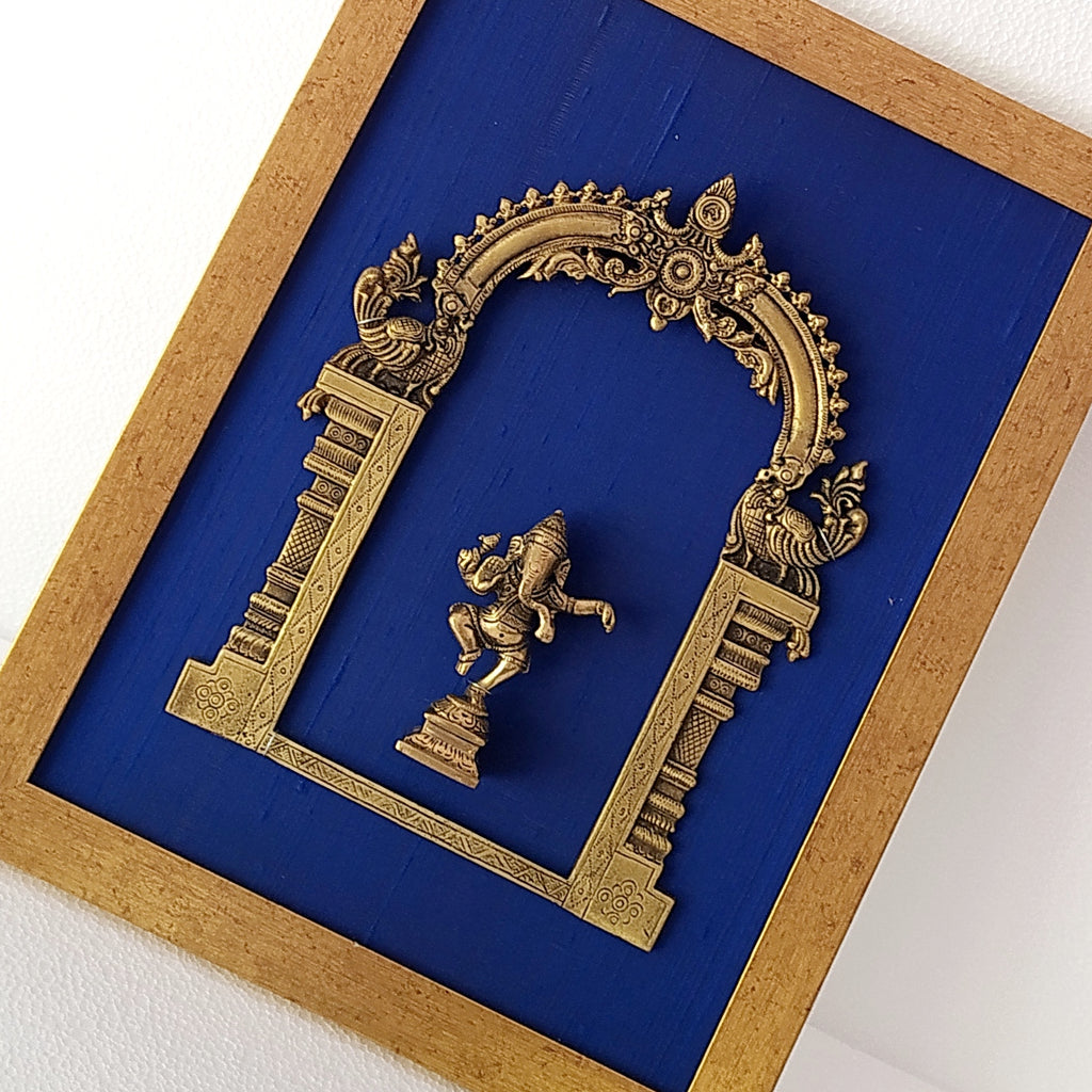 Divine Brass Prabhavali Framed On Deep Blue Raw Silk With Dancing Ganesha In Antique Gold Frame. Height 45 cm x Width 35 cm