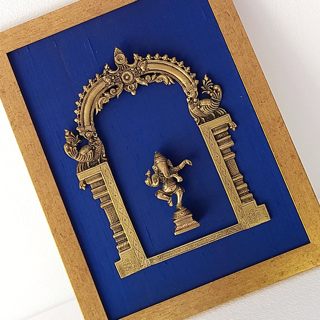 Divine Brass Prabhavali Framed On Deep Blue Raw Silk With Dancing Ganesha In Antique Gold Frame. Height 45 cm x Width 35 cm